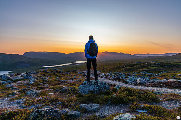 Man admiring the sunset on Saana hiking trail in Kilpisjärvi, Enontekiö, Lapland, Finland